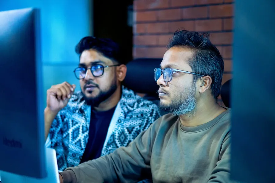 Two people looking closely at a computer screen