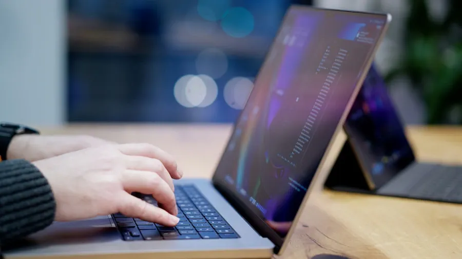 A person working on a laptop by a window