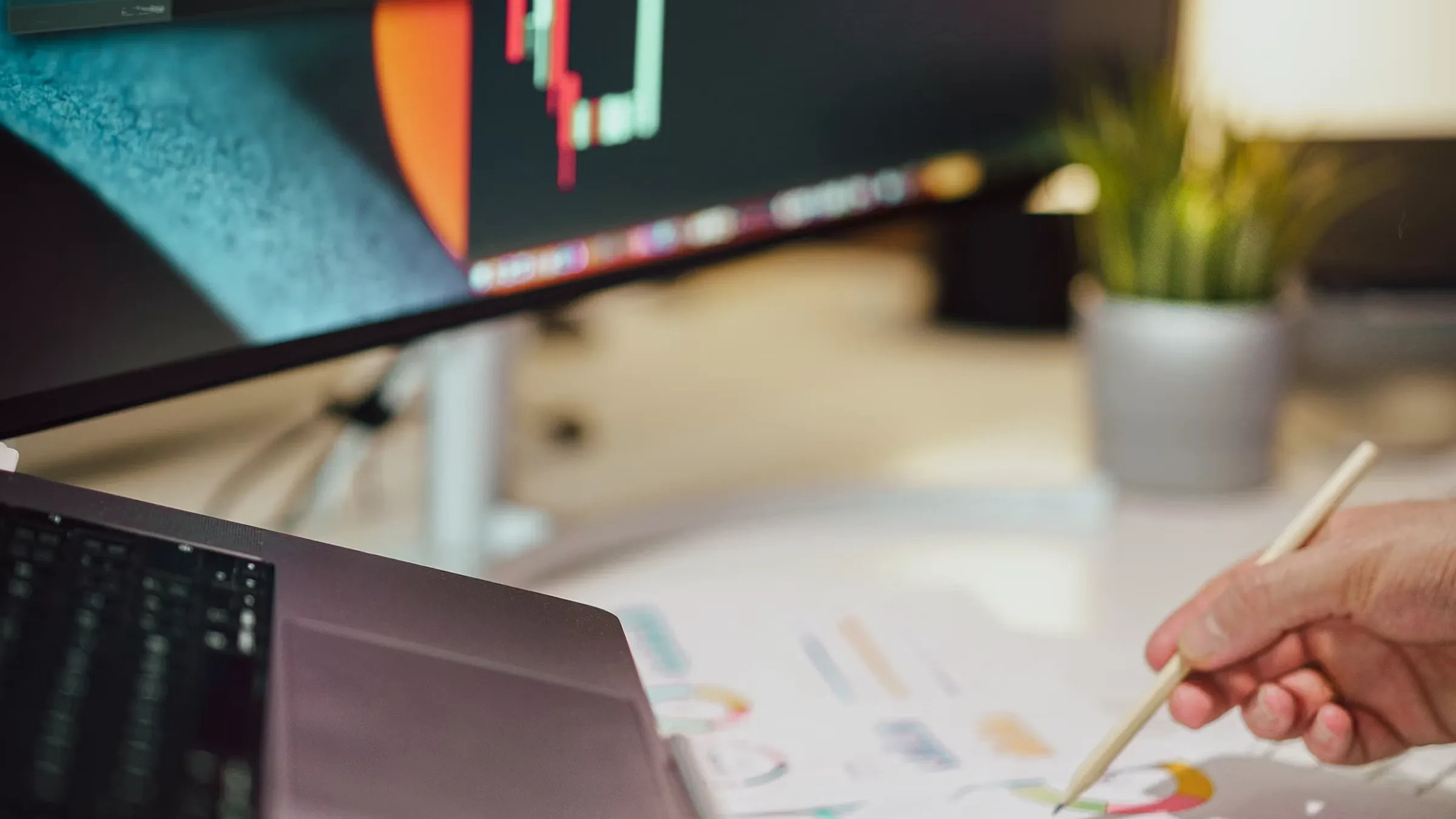 Researcher reviewing backtest results and taking notes beside a monitor