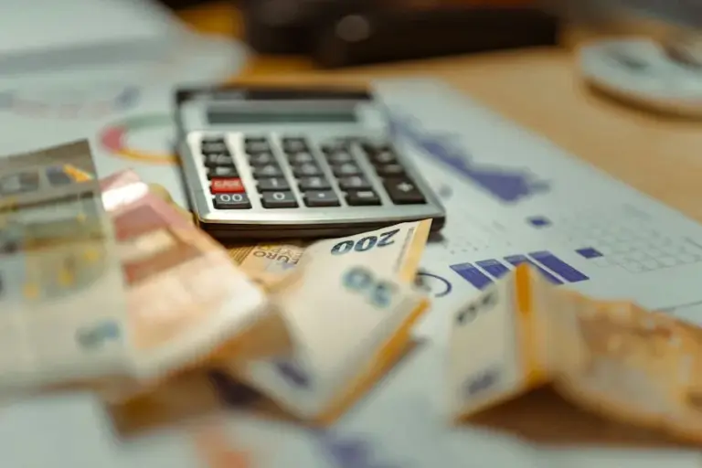 A calculator resting on a stack of banknotes
