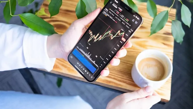 A person using a mobile trading app on a smartphone
