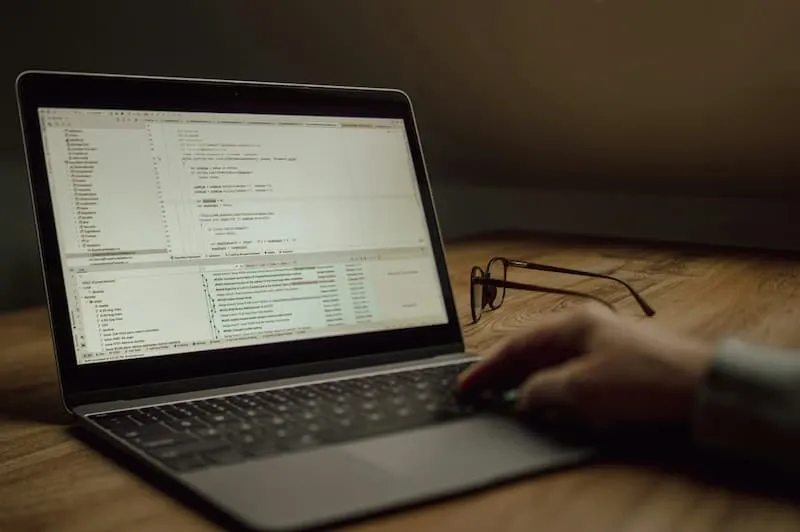 A person typing code on a laptop