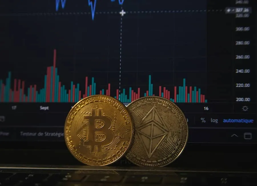 Coins on a laptop before a trading chart