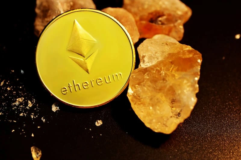 A gold coin resting on stones