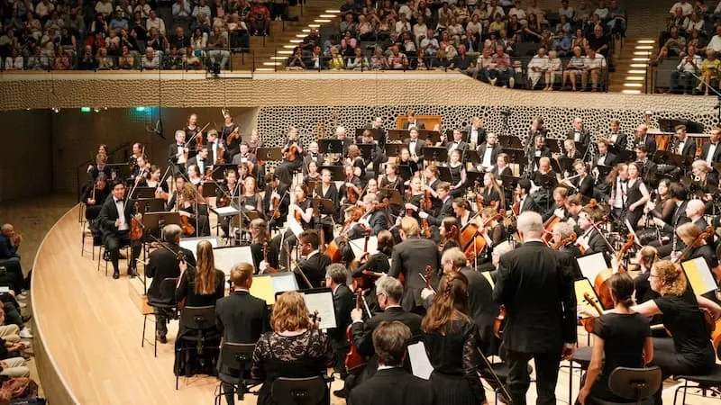 A conductor and orchestra in a hall