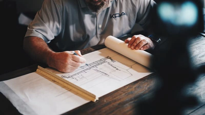 An architect drafting with pencil and ruler