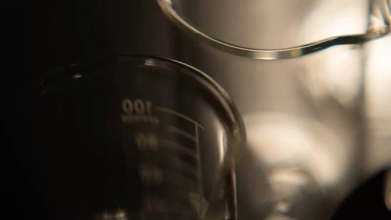 Several glass beakers on a dark background