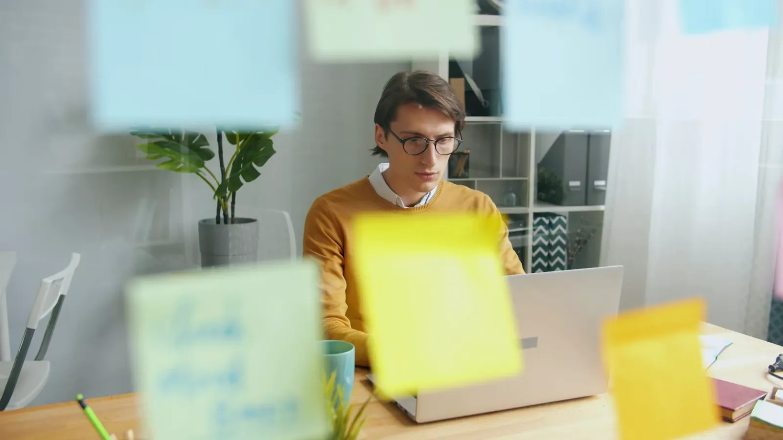 A person working at a laptop with notes