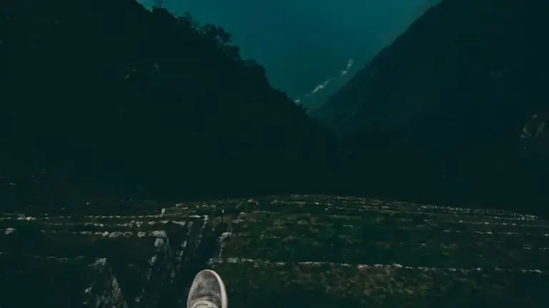 A person standing on a mountain peak looking