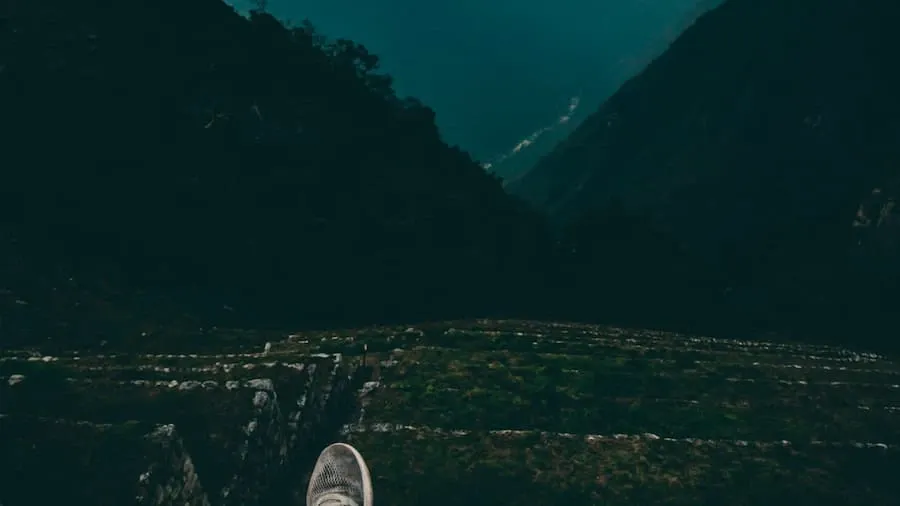 A person standing on a mountain peak looking