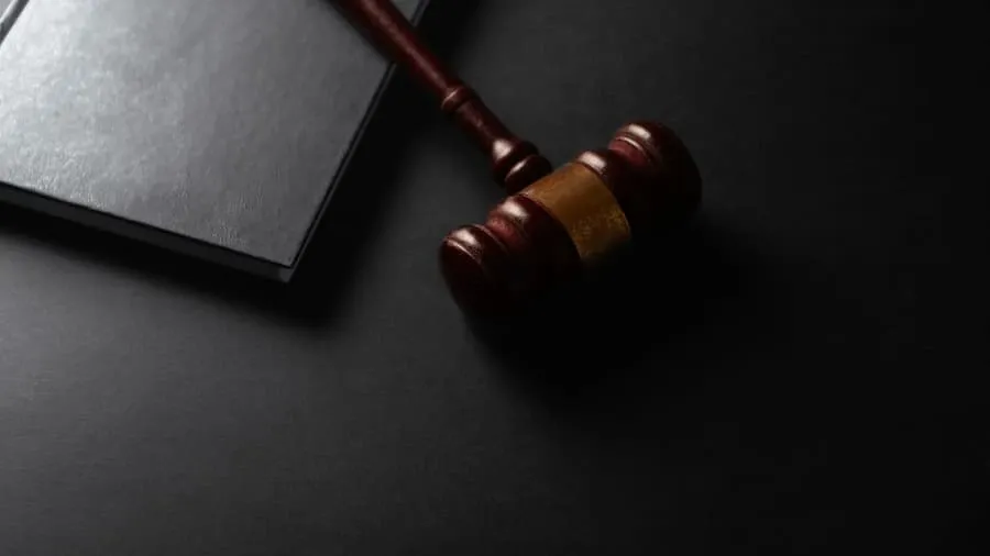 A wooden gavel resting next to a book