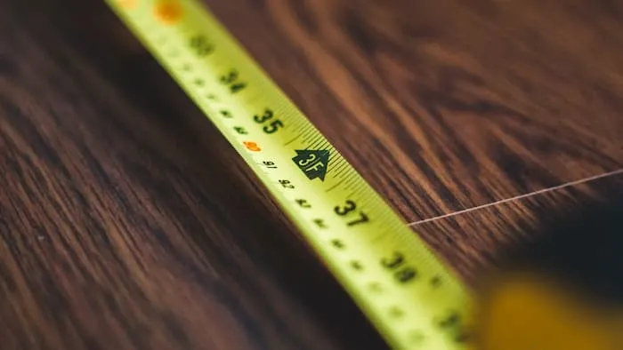 A yellow tape measure on a wooden surface