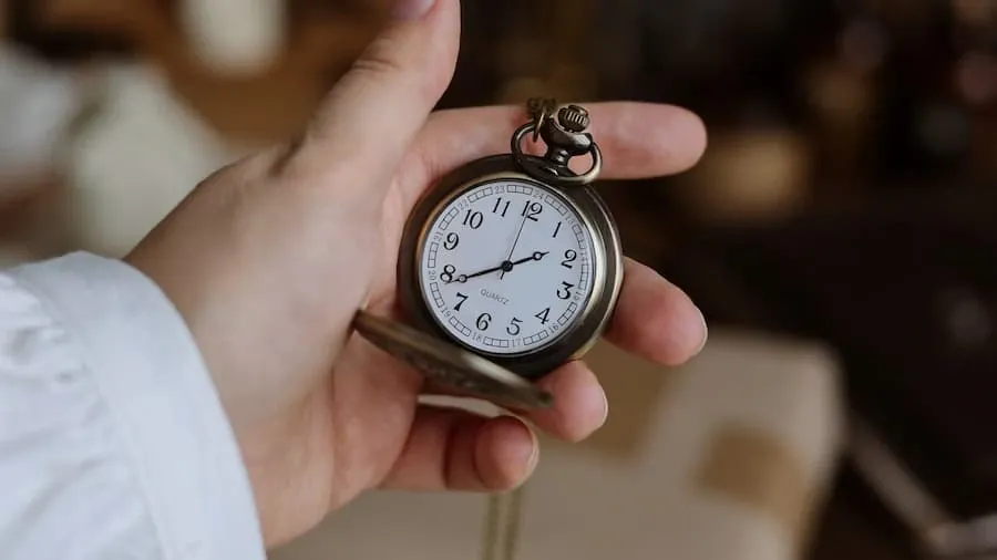 An open pocket watch held in a hand
