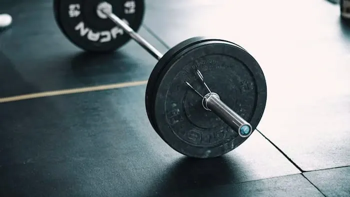 A loaded barbell resting on a gym floor